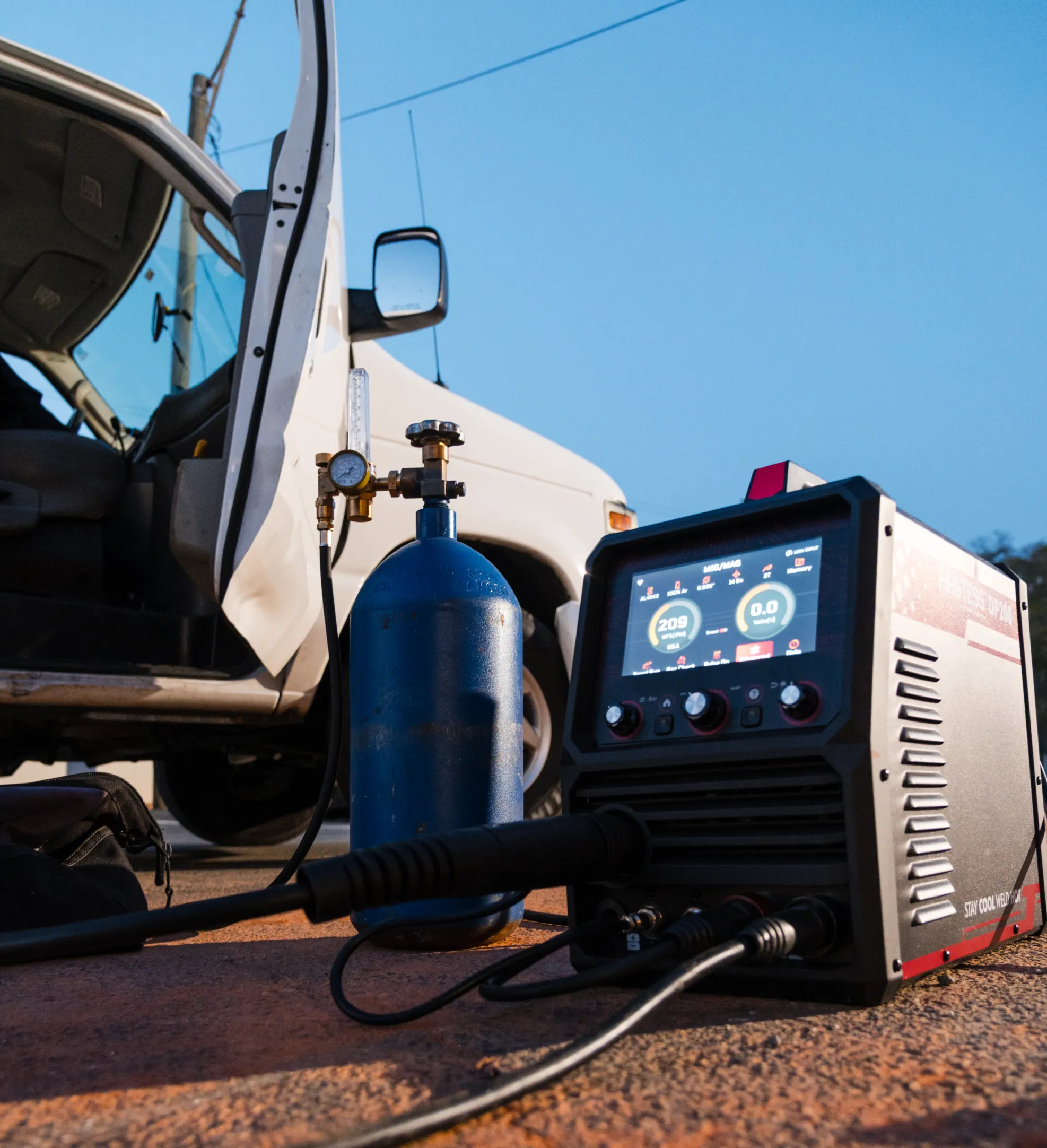 emergency-2 A gas cylinder and welding machine sit next to an open van door on a paved surface at dusk.